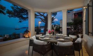 a dining table on a balcony with a view of the ocean at Villa L'orizzonte in Slatine