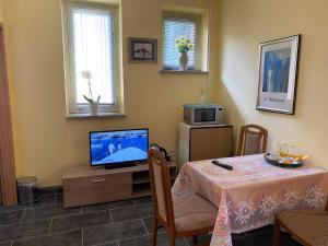 a living room with a table and a television at Ferienwohnung Goldener Drache in Hohekreuz