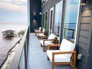 a row of chairs sitting on a balcony overlooking the ocean at Upscale Condo Full Kitchen Balcony Rooftop Pool in Jacksonville