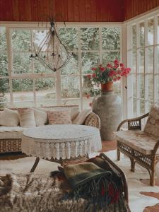 a living room with a couch and a table and windows at Muhu Tõnise Talu in Liiva