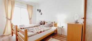 a bedroom with two beds and a large window at MB Deluxe Apartment in Visoko