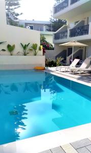 una piscina de agua azul frente a un edificio en Melitti Hotel, en Rethymno