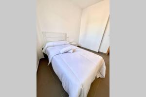 due letti in una stanza con lenzuola bianche di APTO LOS MOLINOS, LUCENA DEL CID BAJO B Ref 047 a Lucena del Cid