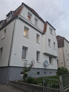 - un bâtiment blanc avec des fenêtres sur le côté dans l'établissement Charmantes helles Zimmer zentrumnah und naturnah, à Göppingen