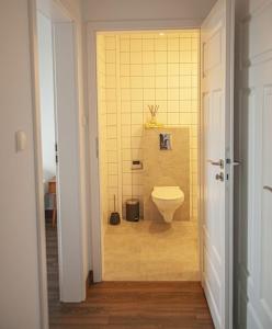 a bathroom with a toilet and a yellow wall at Przytulny Apartament Mickiewicza 14/5 in Wieleń
