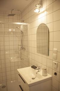 a white bathroom with a sink and a shower at Przytulny Apartament Mickiewicza 14/5 in Wieleń
