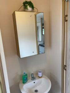 a bathroom with a sink and a mirror at 5 mins walk to beach. 3 bedroom caravan. Sleeps 8 in Clacton-on-Sea