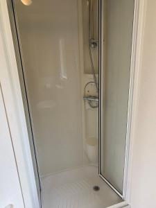 a shower with a glass door in a bathroom at 5 mins walk to beach. 3 bedroom caravan. Sleeps 8 in Clacton-on-Sea