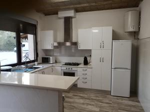 a kitchen with white cabinets and a white refrigerator at Casas Rurales Huerto Del Abuelito in Valdeganga