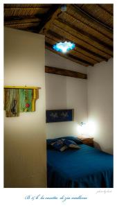 a bedroom with a blue bed and a ceiling at La casetta in Dorgali