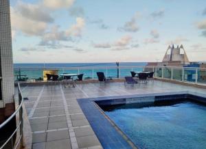 a swimming pool on a building with a view of the ocean at Ponta Negra RN01 in Natal