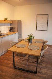 a wooden table in a kitchen with chairs around it at Przytulny Apartament Mickiewicza 14/5 in Wieleń