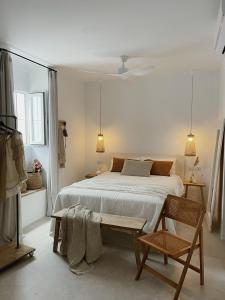 1 dormitorio blanco con 1 cama y 1 silla en Hospedería Boutique Albariza by La Judería De Vejer- ADULTS ONLY, en Vejer de la Frontera