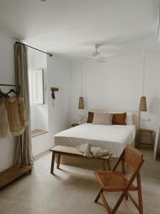 1 dormitorio blanco con 1 cama y 1 silla en Hospedería Boutique Albariza by La Judería De Vejer- ADULTS ONLY en Vejer de la Frontera