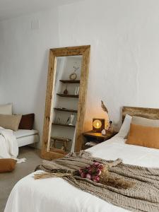 sypialnia z łóżkiem z lustrem i kanapą w obiekcie Hospedería Boutique by La Judería De Vejer- ADULTS ONLY w mieście Vejer de la Frontera
