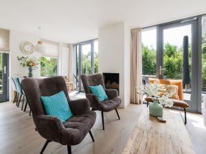 エグモント・アーン・デン・フフにあるHoliday home in Egmond aan den Hoef with saunaのリビングルーム(椅子、暖炉付)