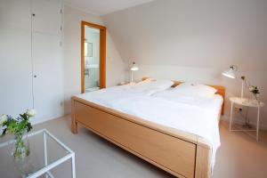 Un dormitorio con una gran cama blanca y una mesa de cristal en Lohmann`s, en Garstedt