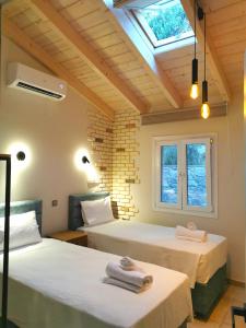 due letti in una stanza con lucernario di Anna's cottage house a Perama