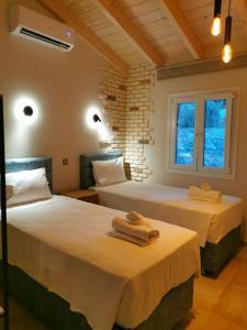 una camera da letto con due letti con asciugamani sopra di Anna's cottage house a Perama