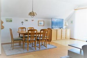 ein Esszimmer mit Tisch und Stühlen und einem Fernseher in der Unterkunft FeWo-Norden in Norden