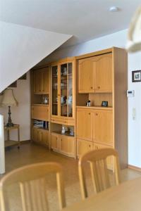 eine Küche mit Holzschränken und einem Tisch und Stühlen in der Unterkunft FeWo-Norden in Norden