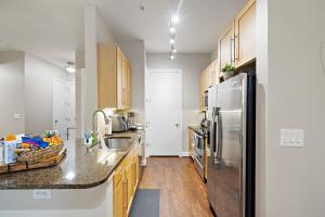 una cocina con nevera de acero inoxidable y armarios de madera en Corporate rental unit City Centre, Energy Corridor en Houston
