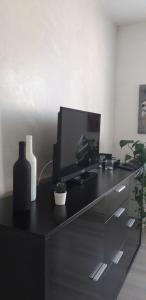 a black desk with a tv and a computer on it at COSY F3 PROCHE CENTRE in Belfort