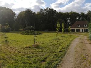 un campo con una casa y un camino de tierra en Le Gîte du Parc, en La Coquille