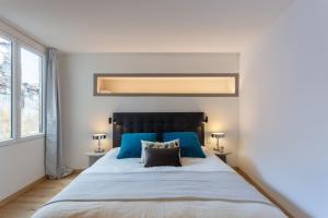 a bedroom with a large bed with blue accents at Duplex Flamingo, l'Hauture, Arles in Arles