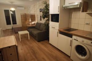 Una cocina y una sala de estar con un sofá y una mesa. en Trés beau studio 35 M2 Entre Mer et Forêt grand jardin et douche tropicale, en La Seyne-sur-Mer