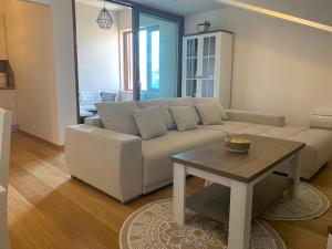 ein Wohnzimmer mit einem weißen Sofa und einem Tisch in der Unterkunft Apartman Mujo in Cres