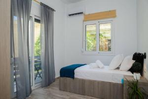 una camera con un letto, una finestra e un balcone di Potnia House in the center of Rhodes a Città di Rodi