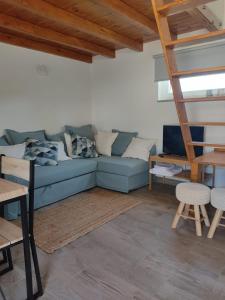 a living room with a blue couch and a ladder at Villa Vista in Sesimbra