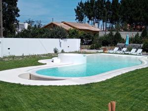 a swimming pool in a yard with chairs around it at Apartamento, wi-fI, terrasse in Vagos