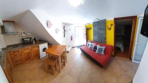 a living room with a red couch and a table at Casinha dos Figueirais in Góis