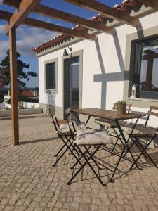 a picnic table and chairs in front of a house at Villa Vista in Sesimbra