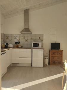 a kitchen with white cabinets and a stove top oven at Villa Vista in Sesimbra