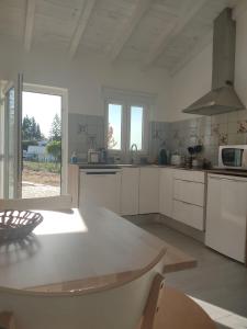 cocina con armarios blancos y encimera blanca en Villa Vista en Sesimbra