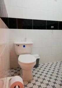 a bathroom with a toilet and a black and white tile floor at Casa Lucía - Guatapé in Guatapé