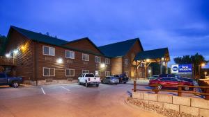 a large building with cars parked in a parking lot at Best Western Devils Tower Inn 