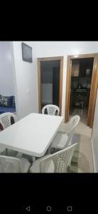 una mesa blanca y sillas en una habitación en Sweet appartement Gigi en Tetuán