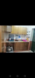 cocina con armarios de madera y fogones en Sweet appartement Gigi en Tetuán