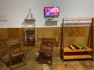 a room with two chairs and a bench and a tv at Castelo das Dunas Camping e MotorHome in Paracuru