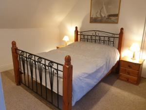 um quarto com uma cama e duas mesas de cabeceira com candeeiros em The horse and panniers guest house. em North Luffenham