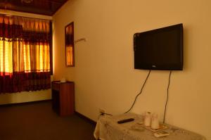 um quarto com uma televisão de ecrã plano na parede em Hotel Hermitage em Sauraha