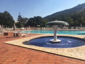 una gran piscina con una sombrilla en el medio en Apart-Hotel Cavalinho Branco (311 e 409 ), en Águas de Lindóia