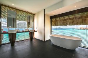 a bathroom with a large tub and a large window at Le Bora Bora by Pearl Resorts in Bora Bora