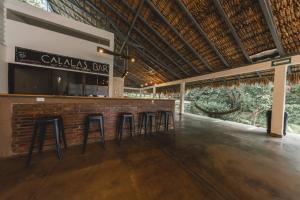 a bar in a building with stools in front of it at Calalas Lodge in Nindirí