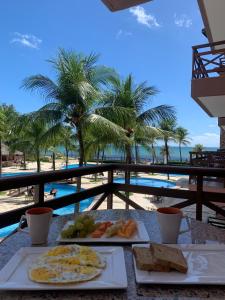 una mesa con comida y vistas a la playa en [Kariri 215] 46m², pé na areia, varanda vista mar!, en Cumbuco