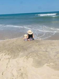 Holden Beach, NC Your Way # 2 في هولدن بيتش: امرأة جالسة على الرمال على الشاطئ